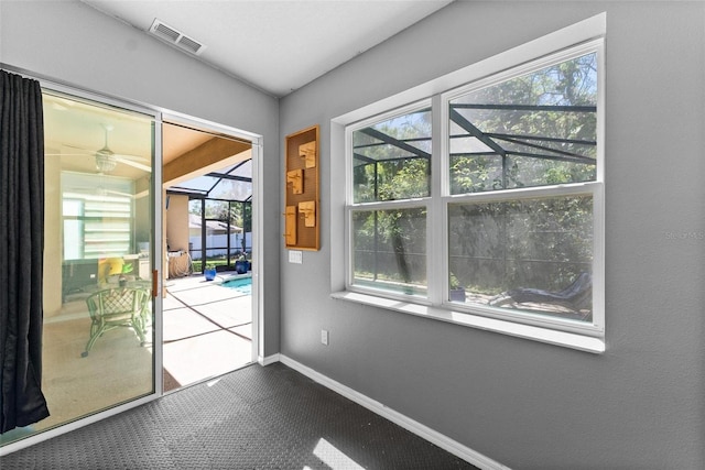 doorway to outside with baseboards, visible vents, a sunroom, and ceiling fan