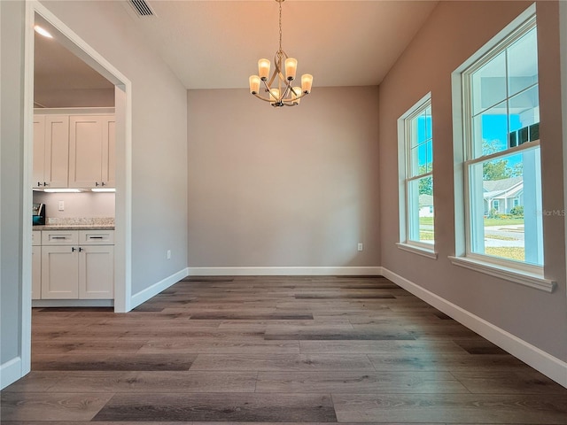 311 W Delaware Ave, Lake Helen, FL 32744 - unfurnished dining area with a chandelier, wood finished floors, and baseboards