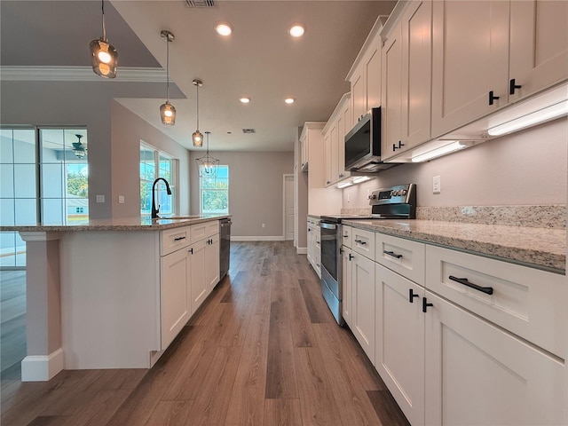 311 W Delaware Ave, Lake Helen, FL 32744 - kitchen featuring stainless steel appliances, a sink, white cabinets, a center island with sink, and recessed lighting