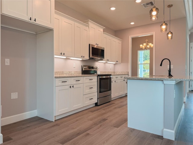 311 W Delaware Ave, Lake Helen, FL 32744 - kitchen featuring stainless steel appliances, light wood-style floors, white cabinets, baseboards, and recessed lighting