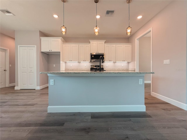 311 W Delaware Ave, Lake Helen, FL 32744 - kitchen featuring stainless steel appliances, white cabinetry, a center island with sink, baseboards, and recessed lighting