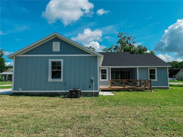 311 W Delaware Ave, Lake Helen, FL 32744 - back of property featuring board and batten siding, a lawn, central AC unit, and a wooden deck