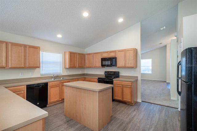 3199 Quail Dr, Deltona, FL 32738 - kitchen featuring light countertops, a kitchen island, lofted ceiling, a sink, and black appliances