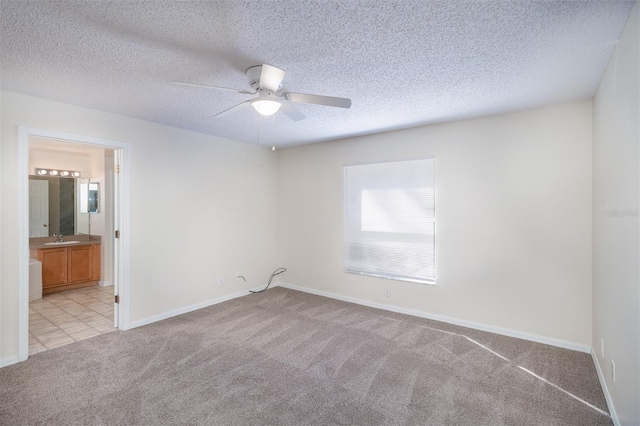 3199 Quail Dr, Deltona, FL 32738 - empty room with a textured ceiling, baseboards, ceiling fan, light carpet, and a sink
