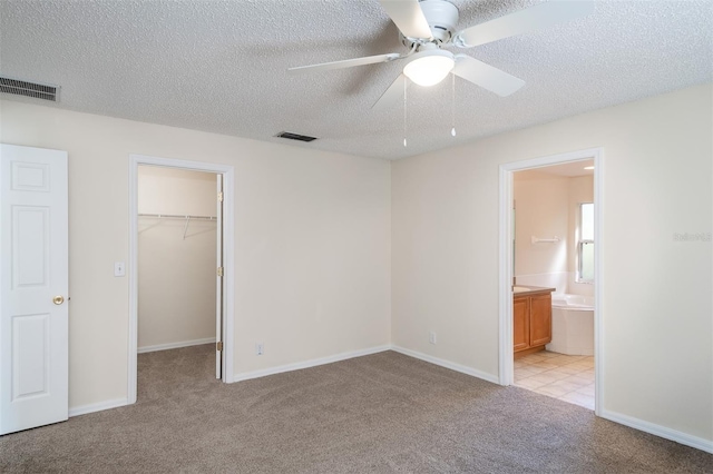 3199 Quail Dr, Deltona, FL 32738 - unfurnished bedroom featuring a textured ceiling, visible vents, a spacious closet, and light carpet