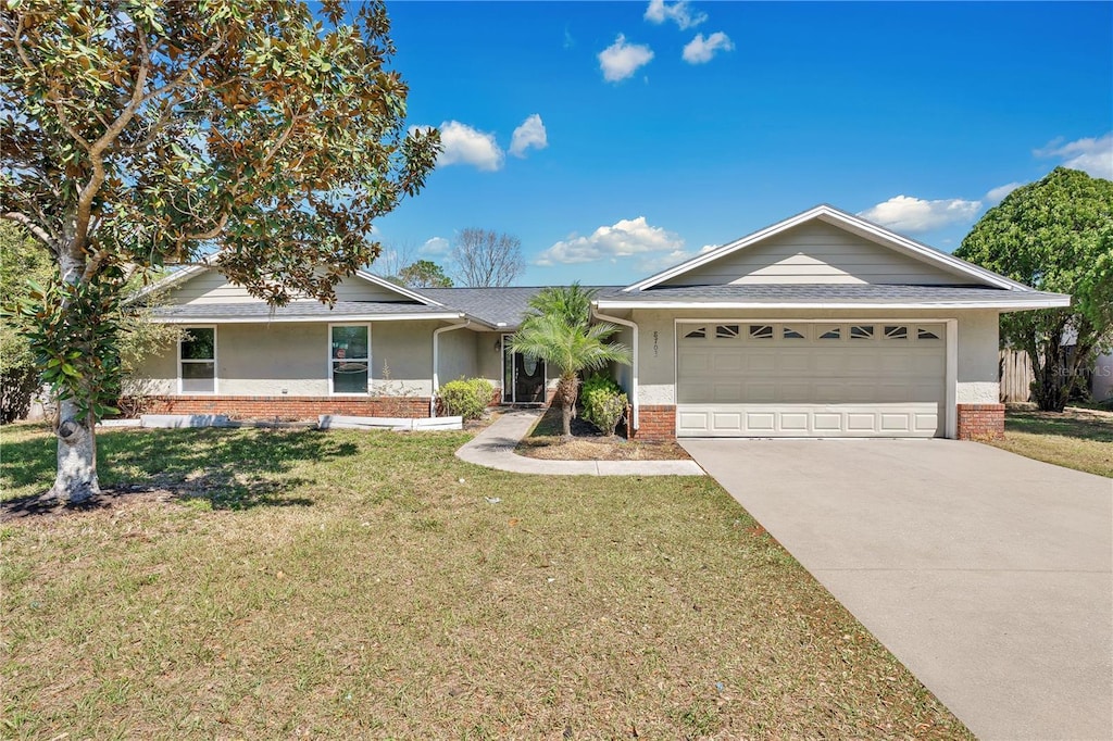 8703 Grandee Dr, Orlando, FL 32829 - single story home with brick siding, driveway, a front lawn, and an attached garage