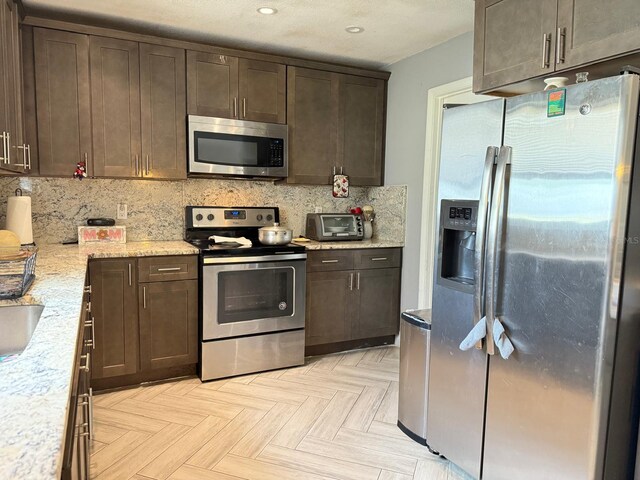 3024 Natoma Way, Orlando, FL 32825 - kitchen with appliances with stainless steel finishes, dark brown cabinetry, backsplash, recessed lighting, and light stone counters