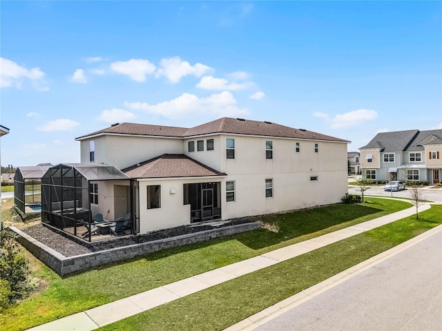 1799 Tropical Palms Cir, Kissimmee, FL 34747 - back of property featuring stucco siding, a lawn, roof with shingles, and glass enclosure