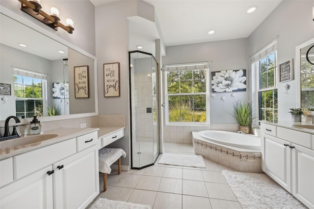 13136 Peregrin Cir, Bradenton, FL 34212 - bathroom featuring plenty of natural light, two vanities, a garden tub, a stall shower, and recessed lighting