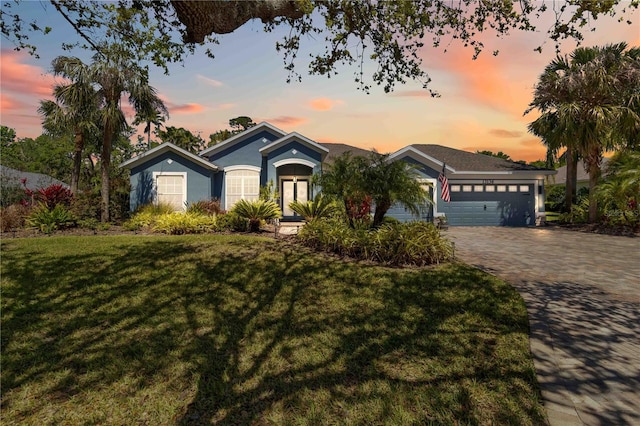13136 Peregrin Cir, Bradenton, FL 34212 - ranch-style house featuring an attached garage, a front yard, decorative driveway, and stucco siding
