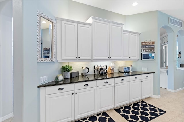 13136 Peregrin Cir, Bradenton, FL 34212 - kitchen with tasteful backsplash, white cabinets, arched walkways, and light tile patterned floors