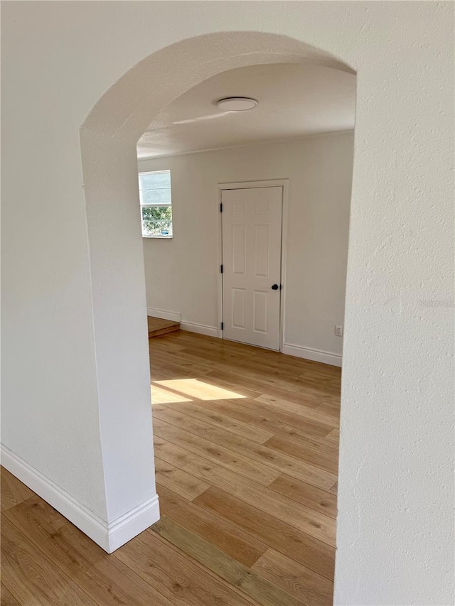 701 N 4th St, Haines City, FL 33844 - corridor with arched walkways, baseboards, and light wood-style floors