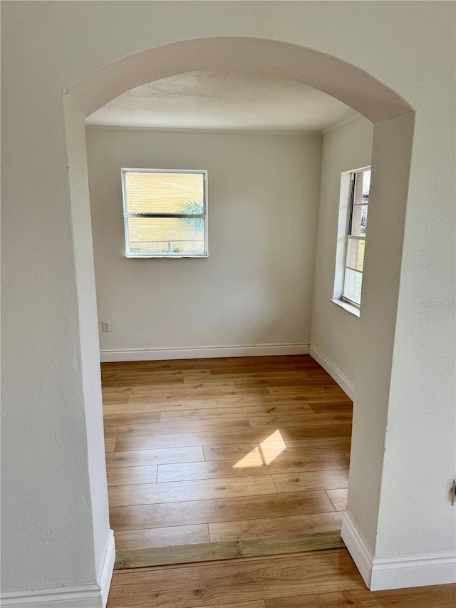 701 N 4th St, Haines City, FL 33844 - spare room featuring arched walkways, hardwood / wood-style flooring, and baseboards