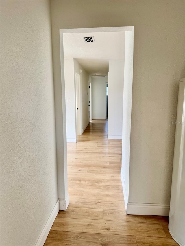701 N 4th St, Haines City, FL 33844 - hall with baseboards, a textured wall, visible vents, and light wood finished floors