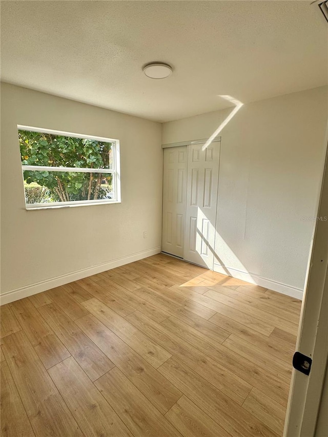 701 N 4th St, Haines City, FL 33844 - empty room with baseboards, light wood-style floors, and a textured ceiling