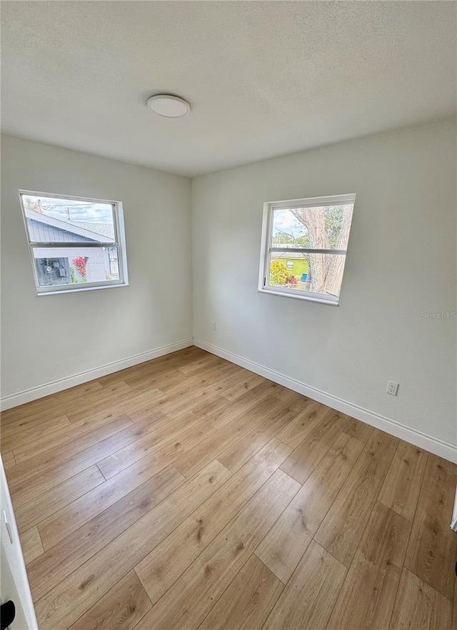 701 N 4th St, Haines City, FL 33844 - empty room with baseboards, light wood finished floors, and a textured ceiling
