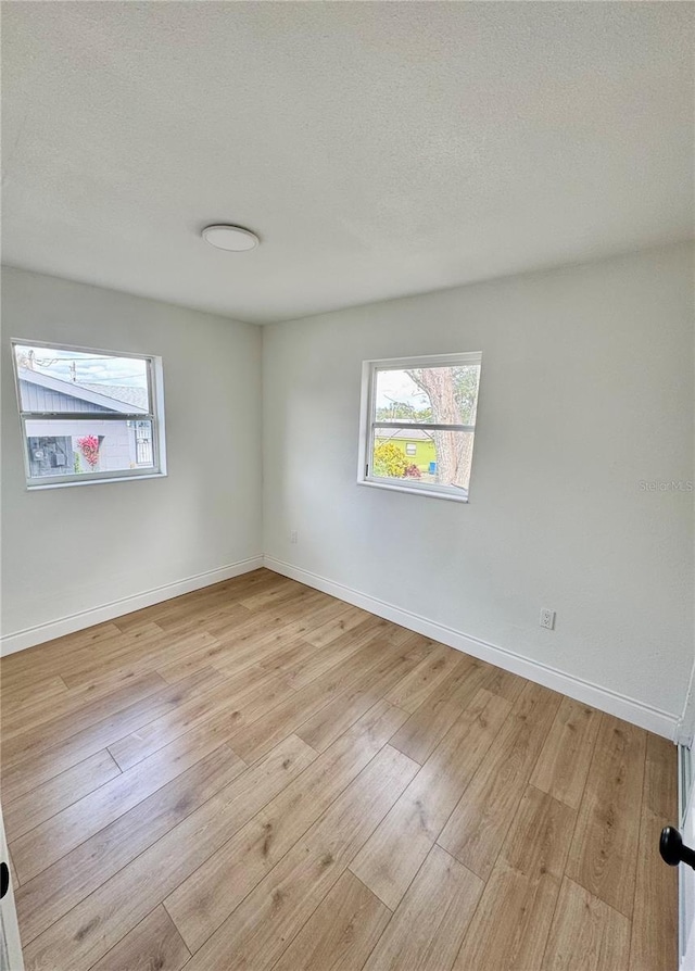 701 N 4th St, Haines City, FL 33844 - spare room featuring light wood-style flooring, plenty of natural light, and baseboards