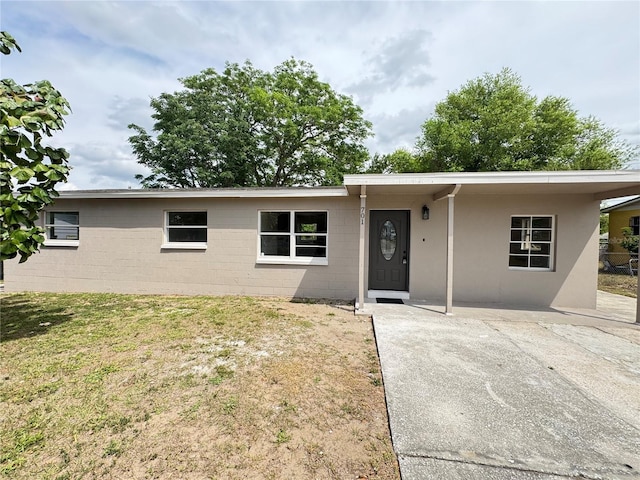 701 N 4th St, Haines City, FL 33844 - single story home with concrete block siding, an attached carport, a front yard, and concrete driveway
