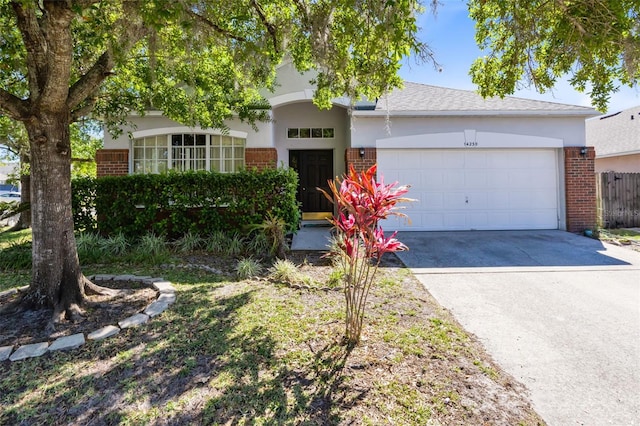 view of front of property featuring stucco siding, brick siding, concrete driveway, and an attached garage