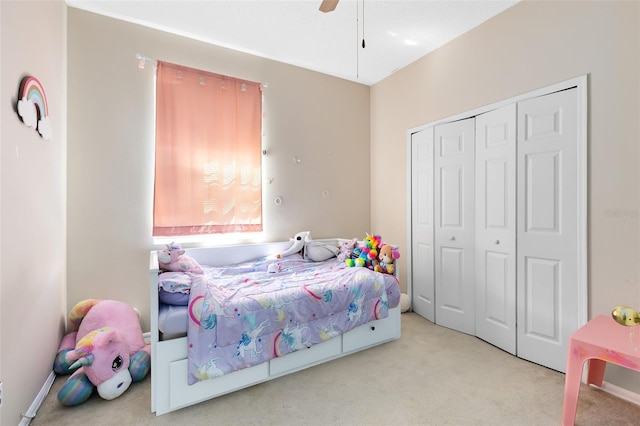 carpeted bedroom with a closet, baseboards, and ceiling fan
