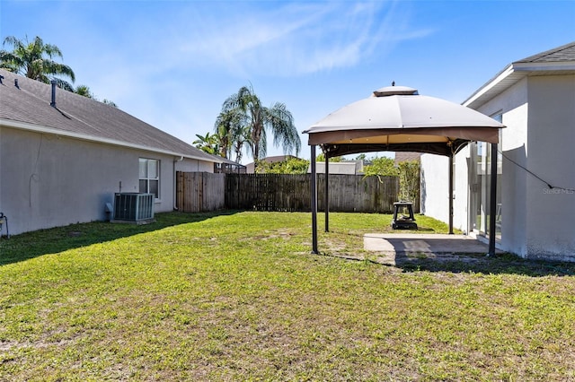 view of yard with a gazebo, fence, and central AC
