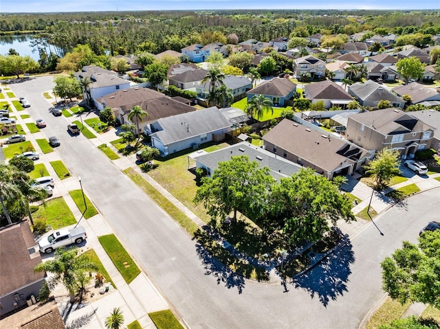 drone / aerial view featuring a residential view, a view of trees, and a water view