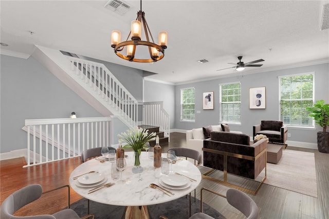 1563 Common Way Rd, Orlando, FL 32814 - dining room featuring crown molding, wood finished floors, stairs, a chandelier, and a ceiling fan