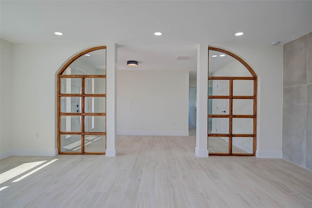 unfurnished room with recessed lighting, wood finished floors, and visible vents