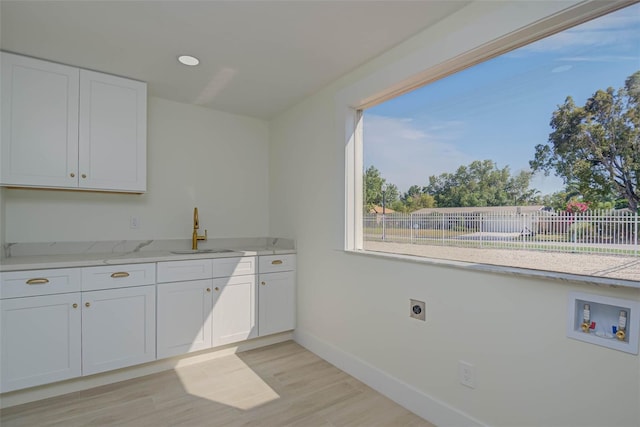 laundry room with a sink, hookup for a washing machine, hookup for an electric dryer, cabinet space, and baseboards