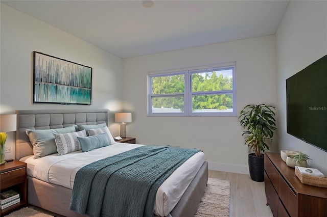 bedroom with light wood finished floors and baseboards