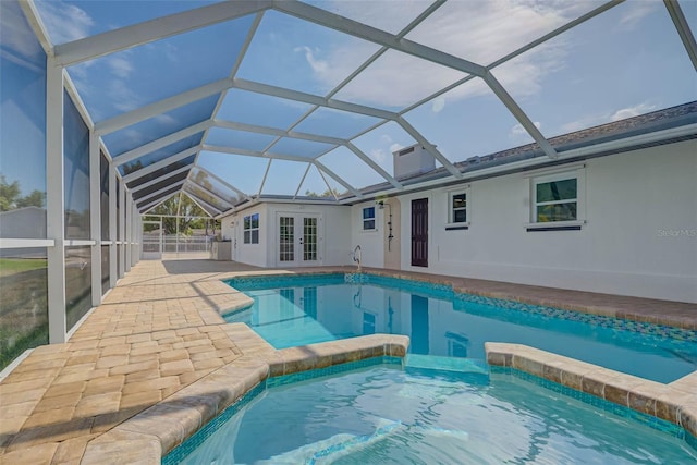 view of swimming pool featuring a patio area, glass enclosure, a pool with connected hot tub, and french doors