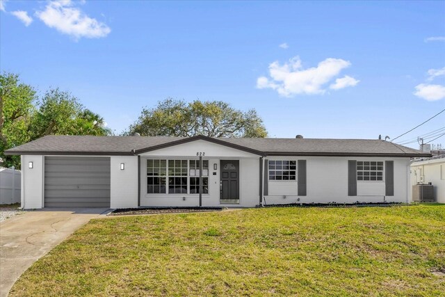 ranch-style house featuring concrete driveway, stucco siding, a front yard, central AC, and a garage