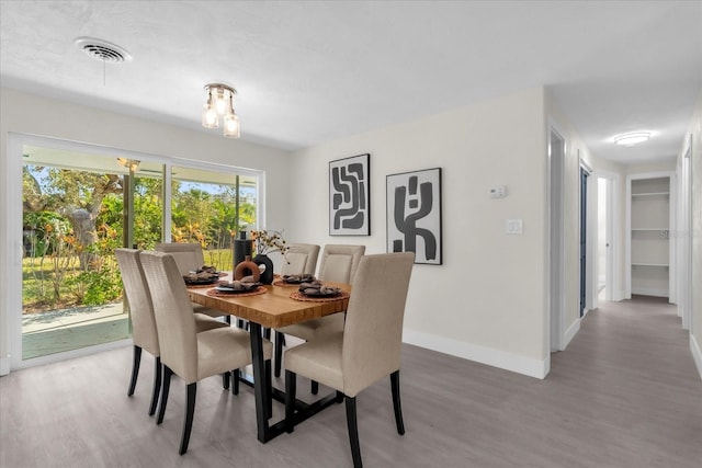 dining room featuring baseboards, visible vents, and light wood-style floors