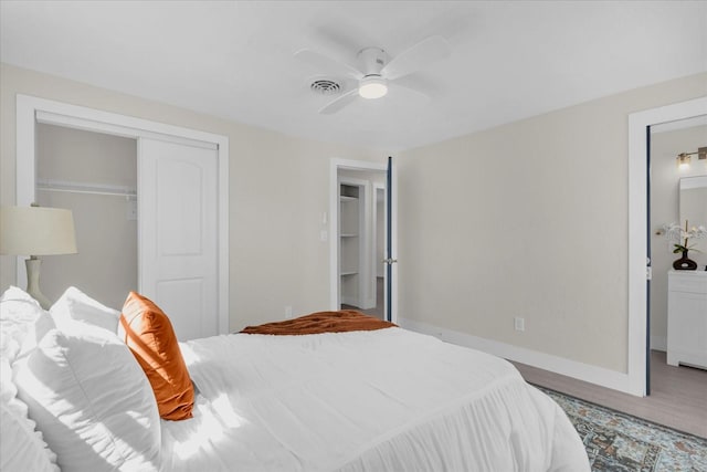 bedroom featuring baseboards, ceiling fan, visible vents, a closet, and wood finished floors