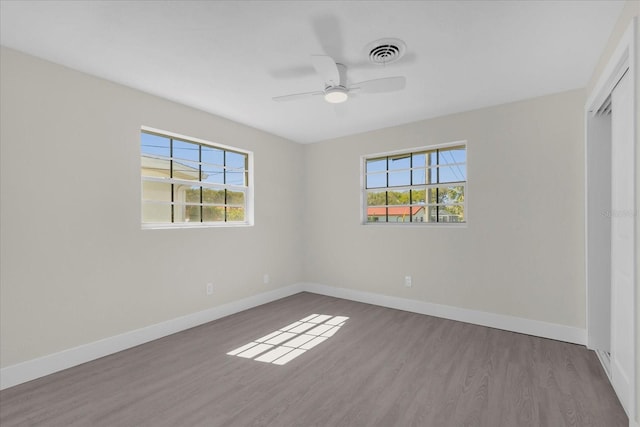 unfurnished bedroom featuring wood finished floors, baseboards, and visible vents