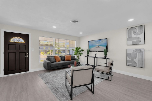 living room with baseboards, visible vents, recessed lighting, and wood finished floors