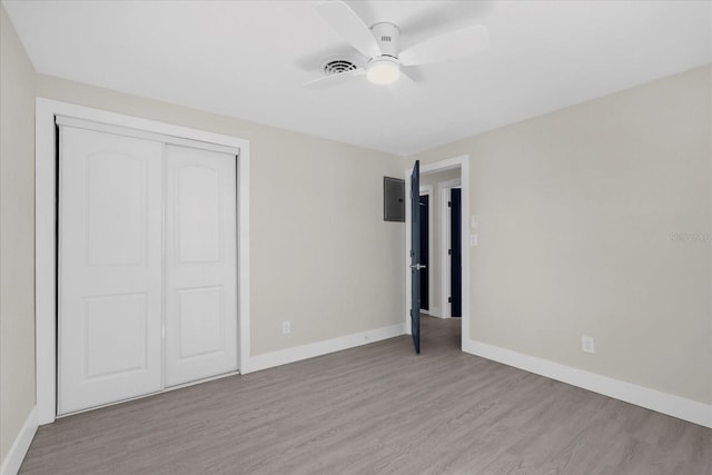 unfurnished bedroom with a closet, a ceiling fan, light wood finished floors, baseboards, and visible vents