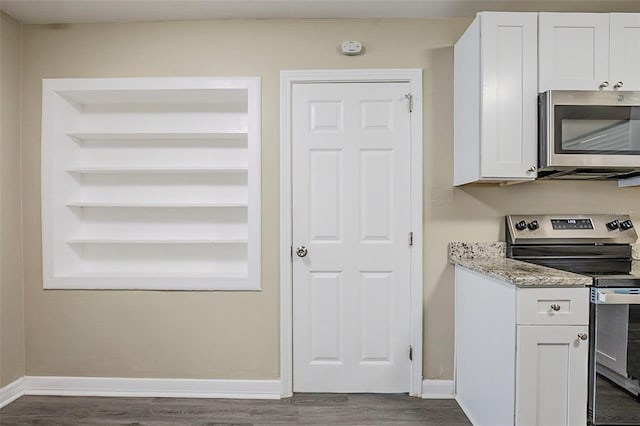 3645 6th St S, Saint Petersburg, FL 33705 - kitchen with white cabinetry, baseboards, dark wood-style floors, light stone countertops, and appliances with stainless steel finishes
