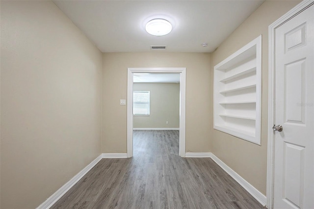 3645 6th St S, Saint Petersburg, FL 33705 - corridor with baseboards, visible vents, wood finished floors, and built in features