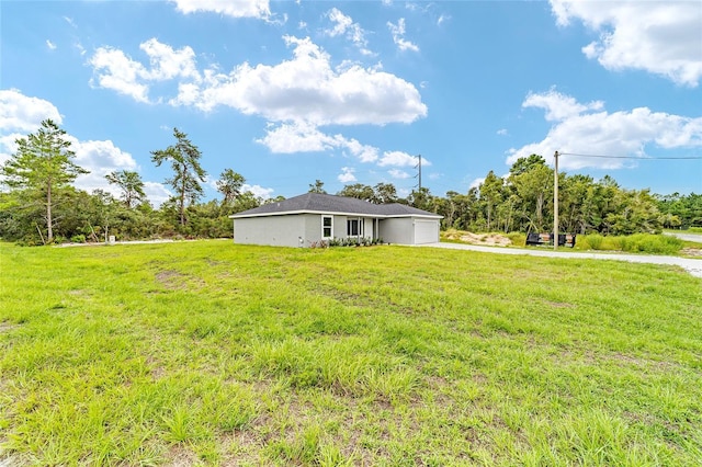 view of yard featuring an attached garage and driveway