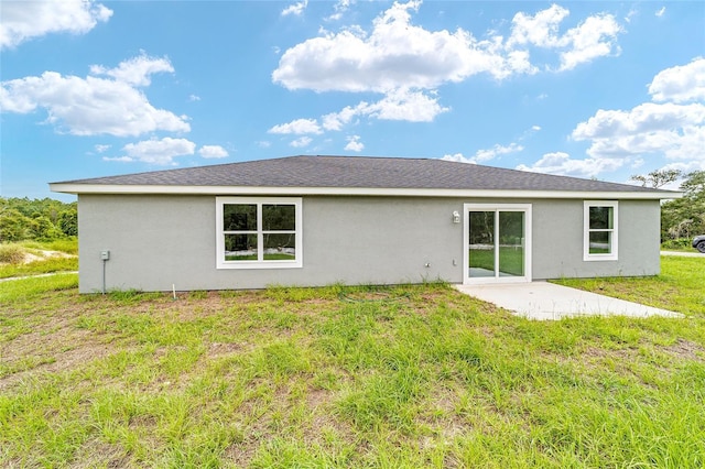 back of house with a patio area, a lawn, and stucco siding