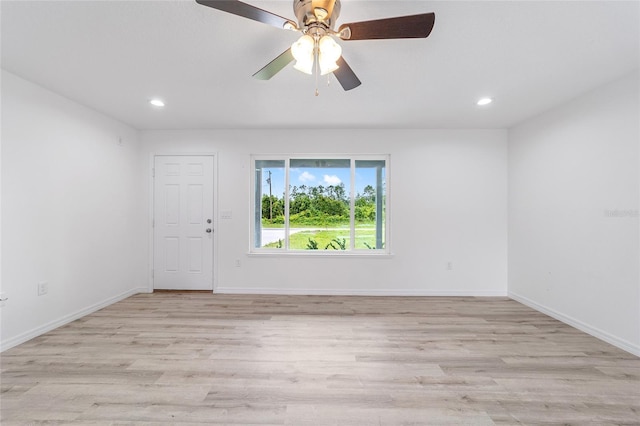 empty room with light wood finished floors, recessed lighting, and baseboards