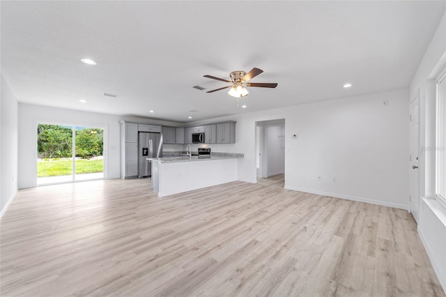 unfurnished living room featuring light wood finished floors, recessed lighting, baseboards, and a ceiling fan