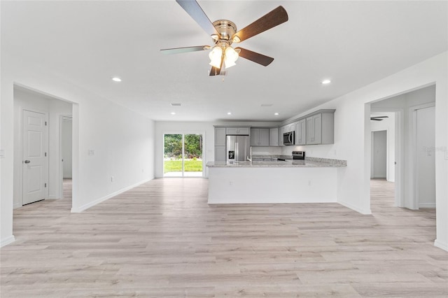 unfurnished living room featuring recessed lighting, a ceiling fan, baseboards, and light wood finished floors