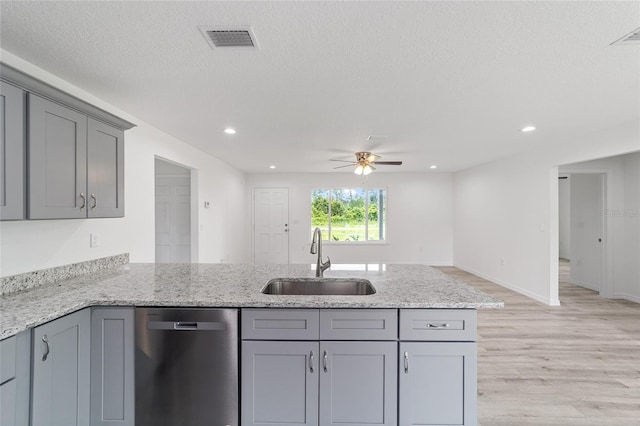 kitchen with visible vents, gray cabinets, dishwasher, and a sink