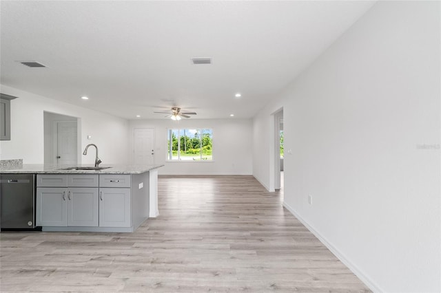 kitchen with visible vents, gray cabinetry, stainless steel dishwasher, and a sink