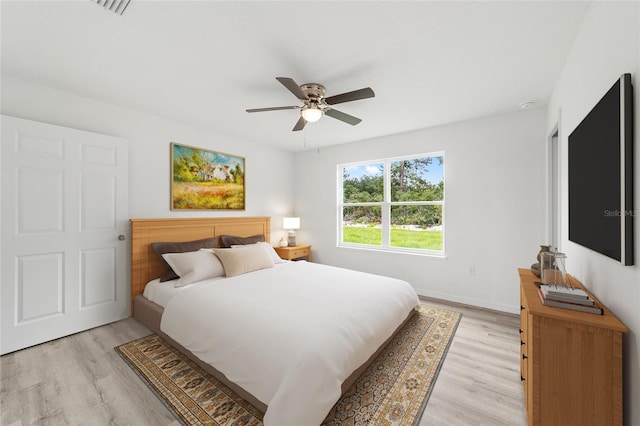 bedroom featuring baseboards, a ceiling fan, and light wood finished floors