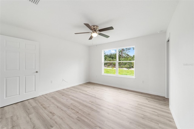 unfurnished room featuring baseboards, light wood-style floors, and a ceiling fan