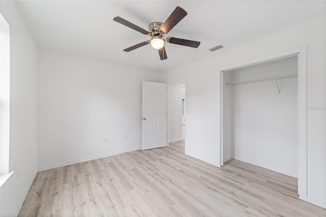 unfurnished bedroom with a ceiling fan, wood finished floors, visible vents, baseboards, and a closet