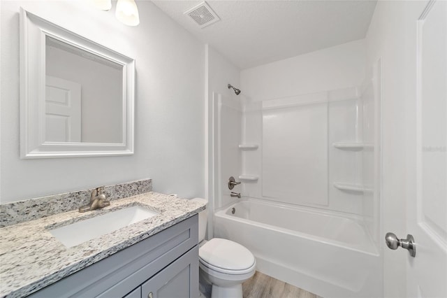 full bathroom featuring visible vents, toilet, vanity, wood finished floors, and a textured ceiling